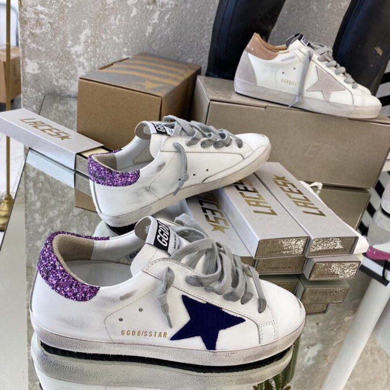 white S*per-star sneakers with blue star and glittery heel tab