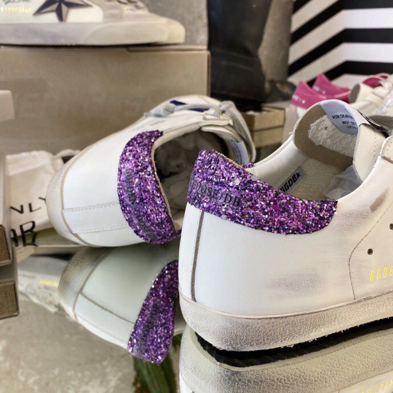 white S*per-star sneakers with blue star and glittery heel tab