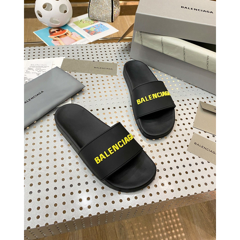 Ba*len*cia*ga pool slide sandal in black rubber with yellow 3d Ba*len*cia*ga logo