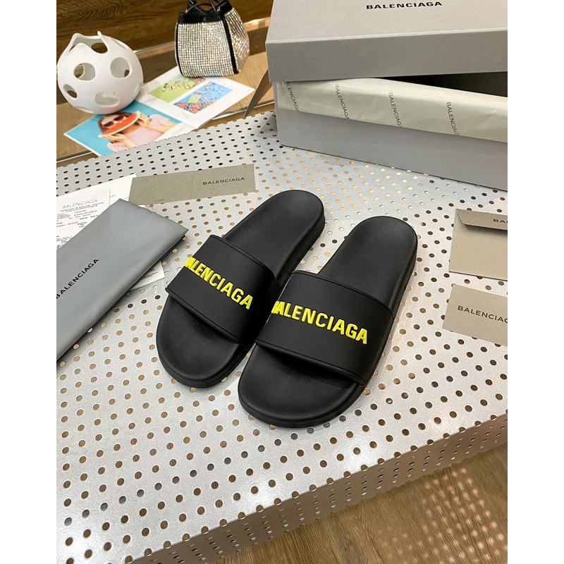 Ba*len*cia*ga pool slide sandal in black rubber with yellow 3d Ba*len*cia*ga logo